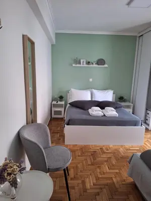 a bedroom with a bed and a chair and a table at Dunant Studio in Athens