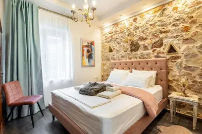 a bed in a room with a stone wall at Queen's stone legend, royal living by Acropolis in Athens