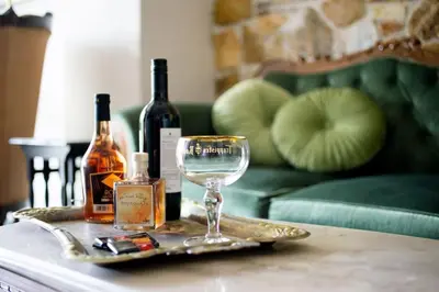 a tray with wine bottles and a glass on a table at Queen's stone legend, royal living by Acropolis in Athens