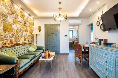 a living room with a couch and a stone wall at Queen's stone legend, royal living by Acropolis in Athens