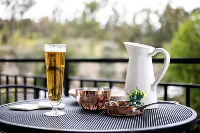 a table with a glass of beer and a vase at Queen's stone legend, royal living by Acropolis in Athens