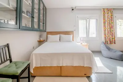 a bedroom with a large bed and a chair at Canto-Home Alongside The Acropolis in Athens