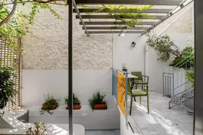 an outdoor patio with a pergola and a table and chairs at Canto-Home Alongside The Acropolis in Athens