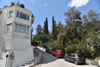 two cars parked on a street next to a building at Canto-Home Alongside The Acropolis in Athens