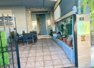 a front porch of a building with a table and chairs at Athens Victoria's studio in Athens