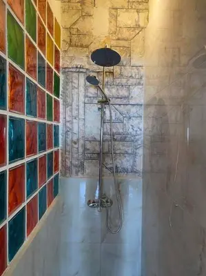 a bathroom with a shower with colorful tiles on the wall at Athens Victoria's studio in Athens