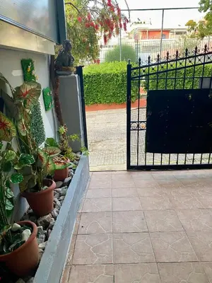 a black gate with potted plants next to a building at Athens Victoria's studio in Athens