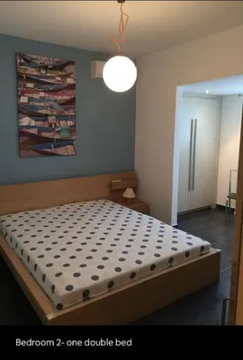 a bedroom with a bed with a comforter on it at Summer House / Πόρτο Ράφτη in Porto Rafti