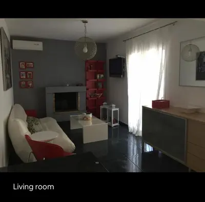 a living room with a couch and a living room with a fireplace at Summer House / Πόρτο Ράφτη in Porto Rafti