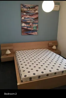 a bed in a room with a painting on the wall at Summer House / Πόρτο Ράφτη in Porto Rafti