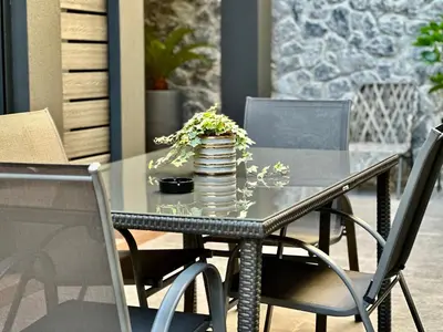 a glass table with a vase of flowers on it at T&T Luxury Apartments - Rooftop Jacuzzi in Athens