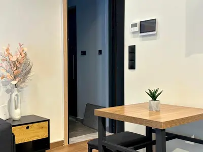 a dining room with a table and a vase with a plant at T&T Luxury Apartments - Rooftop Jacuzzi in Athens