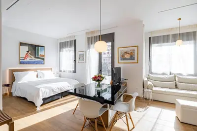 a white bedroom with a bed and a desk and chairs at ART-W Executive Apartments in Athens