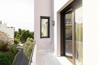 a white house with a balcony with a chair at ART-W Executive Apartments in Athens