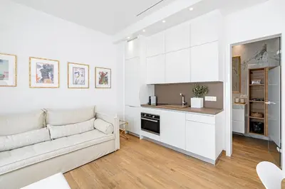 a white living room with a couch and a kitchen at ART-W Executive Apartments in Athens