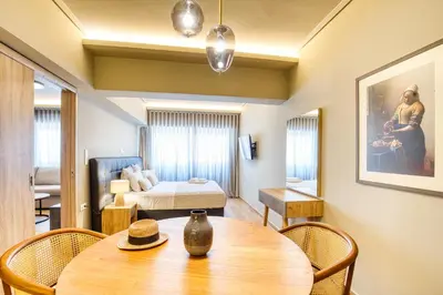 a living room with a table and a bedroom at Ancient Agora Hideaway in Athens
