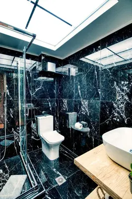 a black bathroom with a toilet and a sink at Ancient Agora Hideaway in Athens