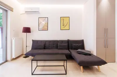 a living room with a couch and a table at Cozy - Bright & New apart. - Downtown in Athens