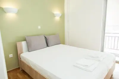 a white bed in a room with a large window at Cozy - Bright & New apart. - Downtown in Athens