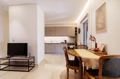 a living room with a dining room table and a kitchen at Cozy - Bright & New apart. - Downtown in Athens