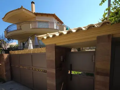a house with a balcony on top of it at Grand Villa Nefeli - Pool & Jacuzzi in Lagonissi