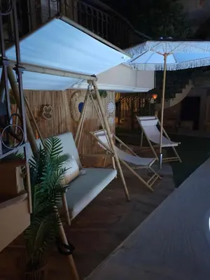 a hammock and chairs under an umbrella on a patio at Grand Villa Nefeli - Pool & Jacuzzi in Lagonissi