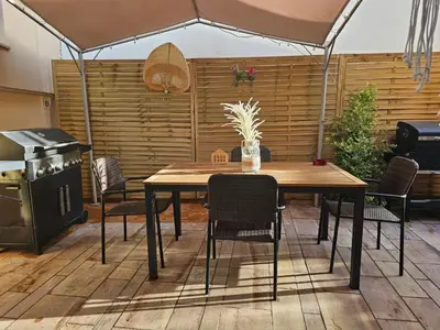 a table and chairs in a patio with an umbrella at Grand Villa Nefeli - Pool & Jacuzzi in Lagonissi