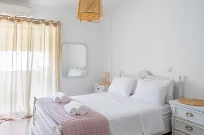 a white bedroom with a bed with towels on a bench at IVY Charm Acropolis View 2BR Apartment Neos Kosmos in Athens