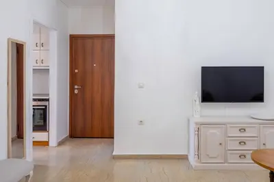 a living room with a television on a white wall at IVY Charm Acropolis View 2BR Apartment Neos Kosmos in Athens
