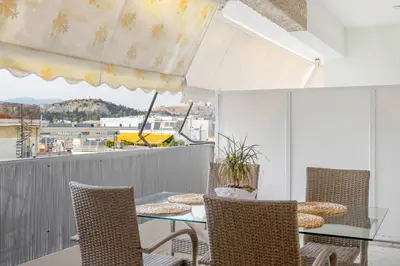 a balcony with a table and chairs and a view at IVY Charm Acropolis View 2BR Apartment Neos Kosmos in Athens