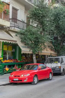 a red car parked on the side of a street at IVY Charm Acropolis View 2BR Apartment Neos Kosmos in Athens