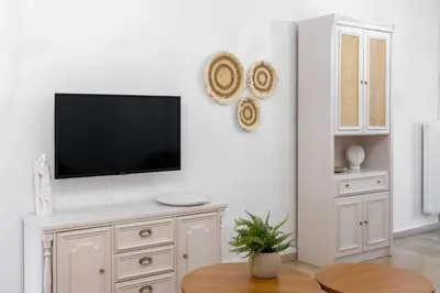 a living room with a tv on a white wall at IVY Charm Acropolis View 2BR Apartment Neos Kosmos in Athens