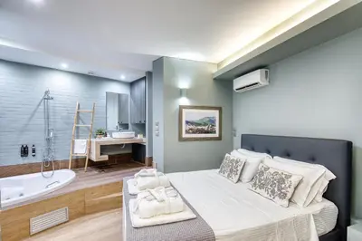 a bedroom with a bed and a tub and a sink at Acropolis Urban View in Athens