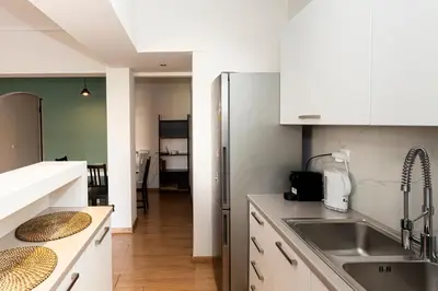 a kitchen with white cabinets and a stainless steel refrigerator at The Glyfada Hideaway in Athens