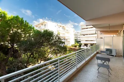 a chair sitting on a balcony with buildings at The Glyfada Hideaway in Athens