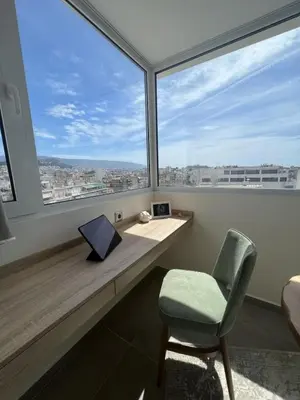 a room with a desk and a chair and large windows at Dafnis View in Athens