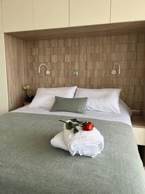 a bed with a white towel with a rose on it at Dafnis View in Athens
