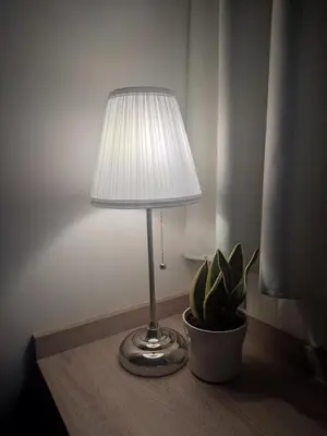 a lamp sitting on a table next to a potted plant at Dafnis View in Athens