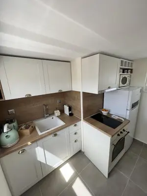a small kitchen with white cabinets and a sink at Dafnis View in Athens
