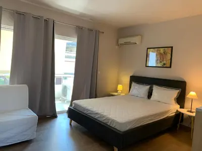 a bedroom with a bed and a large window at Rivi Apartments in Athens