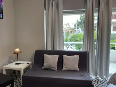 a couch with two pillows in a room with a window at Rivi Apartments in Athens