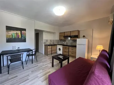 a living room with a couch and a table and a kitchen at Rivi Apartments in Athens