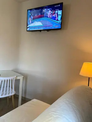 a flat screen tv hanging on a wall in a bedroom at Rivi Apartments in Athens