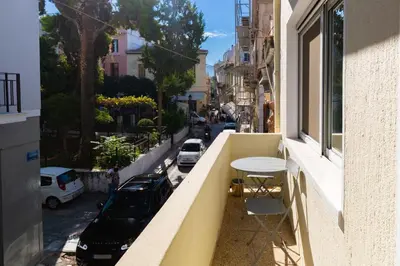a balcony with a table and a view of a street at Luxury Apartments at the foot of the Acropolis Hill in Athens
