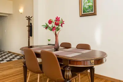 a dining room table with chairs and a vase with flowers at Luxury Apartments at the foot of the Acropolis Hill in Athens