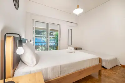 a white bedroom with a large bed and a window at Oculus 2BD Athens Central Escape by Live&Travel in Athens