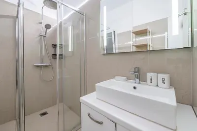a bathroom with a white sink and a shower at Oculus 2BD Athens Central Escape by Live&Travel in Athens