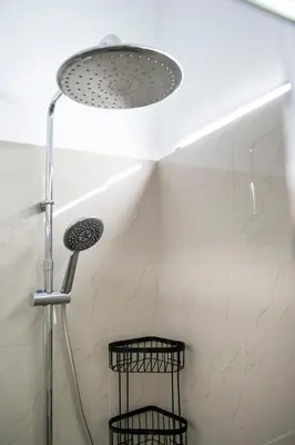 a shower head in a bathroom with two baskets at Oculus 2BD Athens Central Escape by Live&Travel in Athens
