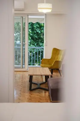 a living room with a chair and a coffee table at Oculus 2BD Athens Central Escape by Live&Travel in Athens