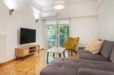 a living room with a couch and a tv at Oculus 2BD Athens Central Escape by Live&Travel in Athens